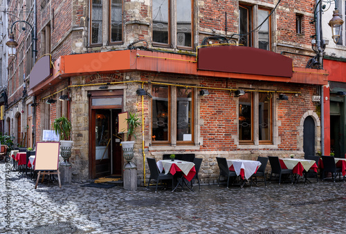 Old street with tables of cafe in center of Brussels, Belgium. Cozy cityscape of Brussels (Bruxelles). Architecture and landmarks of Brussels.