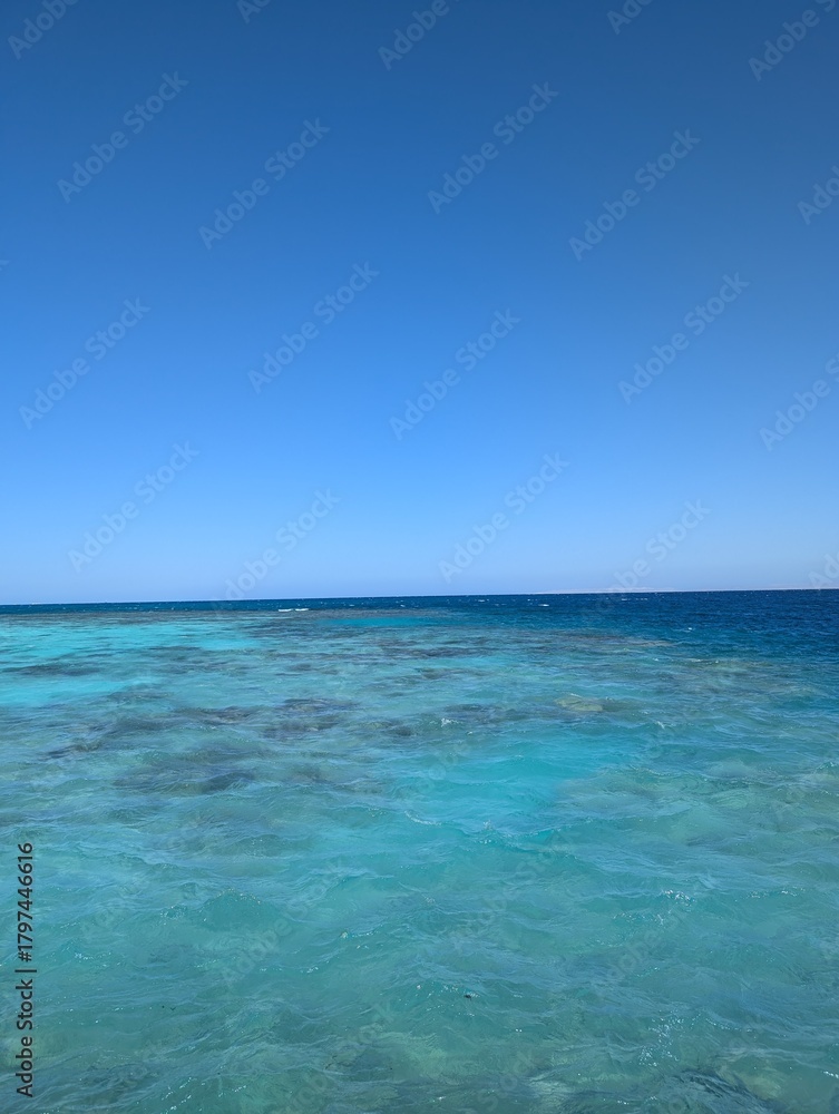 Fototapeta premium Horizon of Tranquility: A breathtaking vista of ocean meets endless sky. Clear, crystalline water reflecting the endless blue above evokes a sense of peace and serenity.