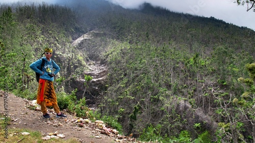 The guy stands against the background of a tropical forest. Adventures in Southeast Asia