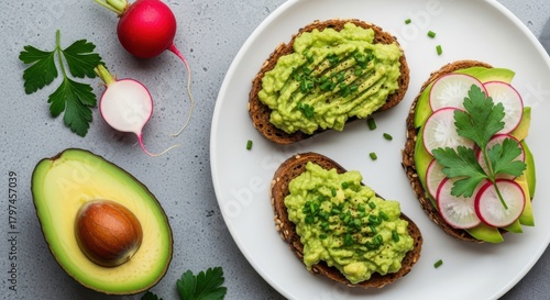 Avocado toast with radish and chives, served on a white plate with fresh avocado and radishes