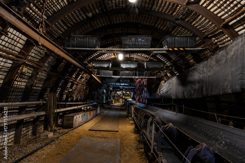 Photos Underground coal mining scene with massive industrial machines operating inside long tunnels and narrow galleries