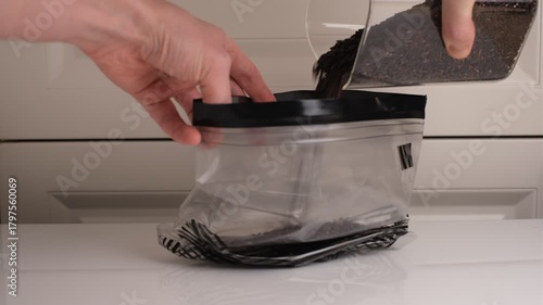 A man pours wild rice from a glass jar into a zip bag