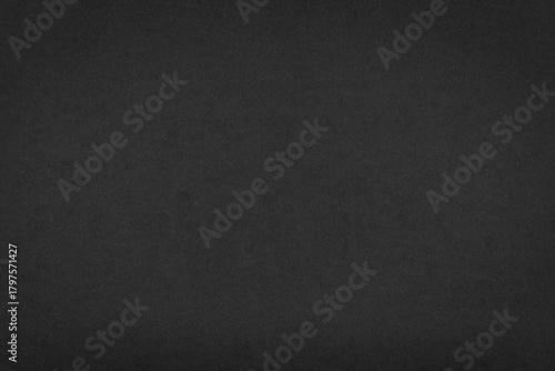 Dark grey paper texture background closeup.