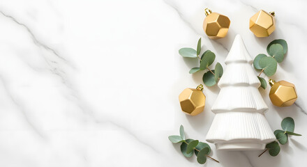 Elegant Christmas holiday background featuring a minimalist white tree, golden baubles, and fresh eucalyptus on a white marble surface