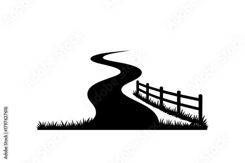 Winding country road disappearing into the distance bordered by a wooden fence