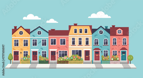Colorful street of cute European-style townhouses with small front gardens, shown on a bright day with a few clouds in the sky.