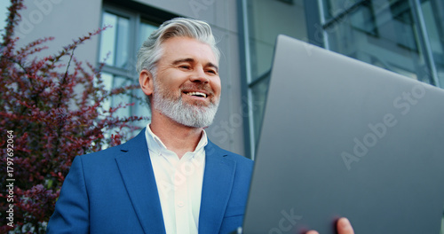 Billede på lærred Close-up of an adult businessman joining a virtual meeting during an important online video call on a laptop