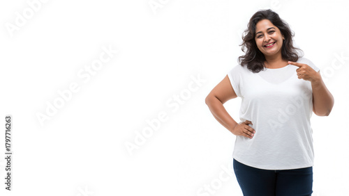 Happy plus size Indian woman in plain white t-shirt and jeans, with pointing pose, isolated on a clean white background.