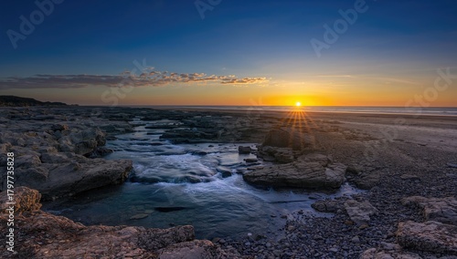 A rocky coastline with a flowing stream cascading over boulders, highlighting erosion risk