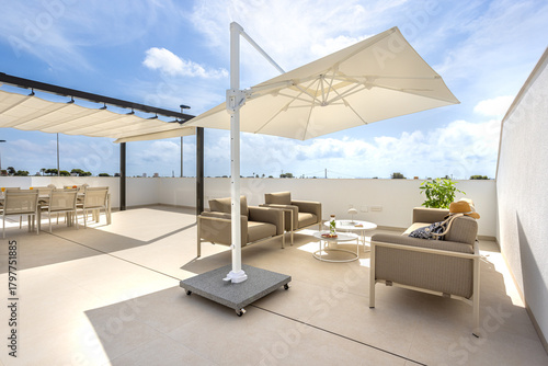 Quadro su tela Sunny rooftop terrace with shaded lounge and seating area