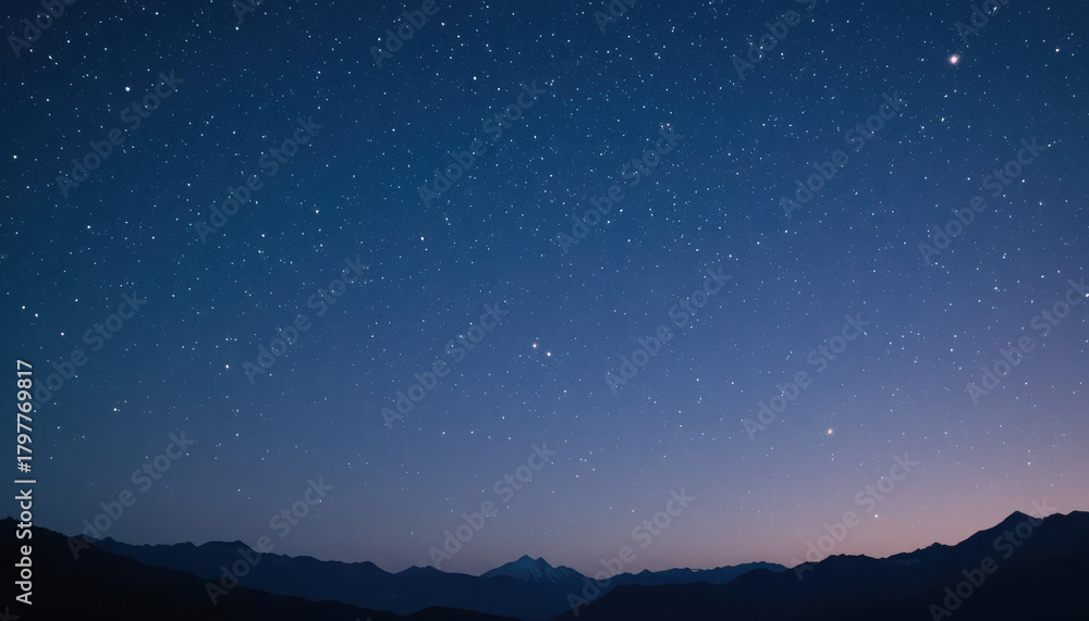 Fototapeta premium Starry night sky above mountains with blue gradient hue
