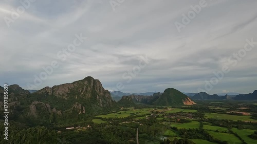 A beautiful aerial view of the lush nature surrounding Vang Vieng, Laos, showcasing mountains, rivers, and green landscapes from above.