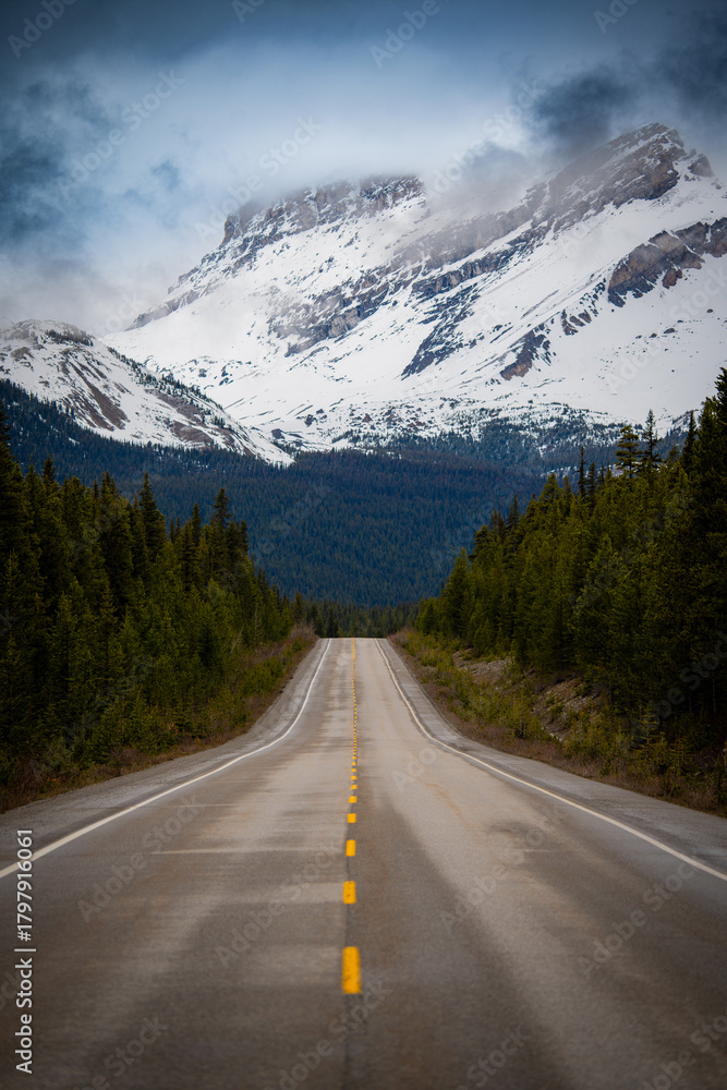 Fototapeta premium Empty mountain highway leading into snowy peaks