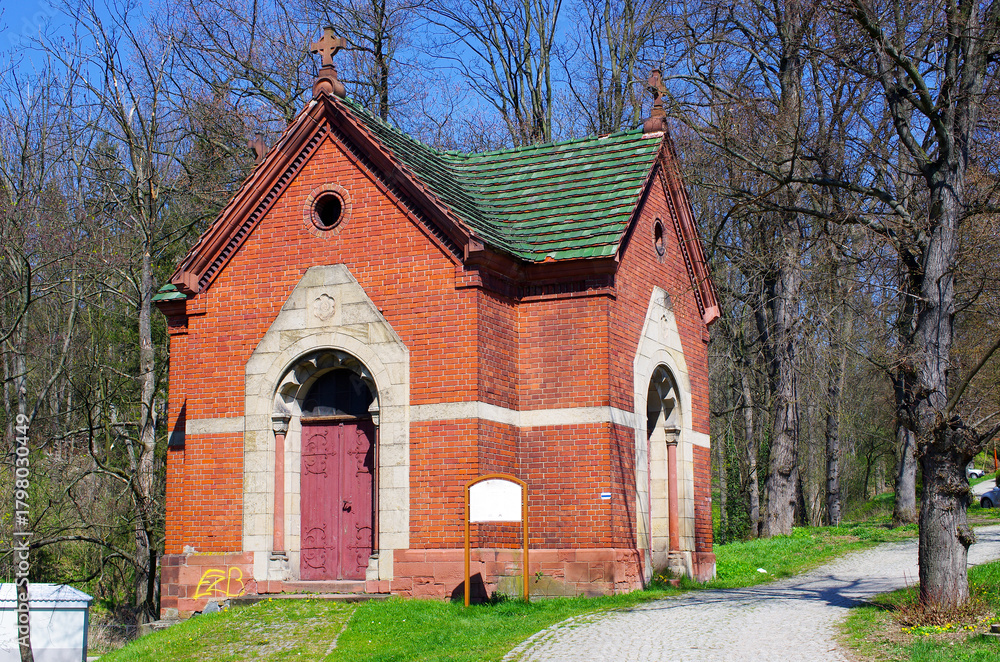 Obraz premium Quaint brick chapel nestled amongst towering trees