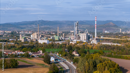 Aerial view of large cement factory complex with industrial smokestacks and quarry, Lafarge cement plant, Czech Republic
