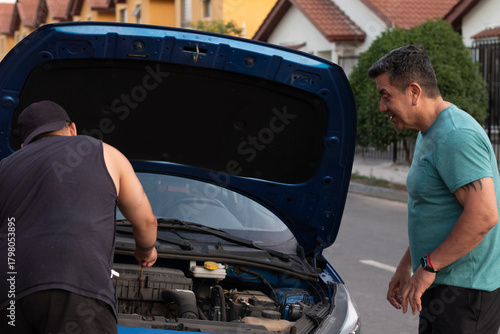 revisando el motor del auto, ayudando a ver un problema con el auto, mecánico revisando un auto