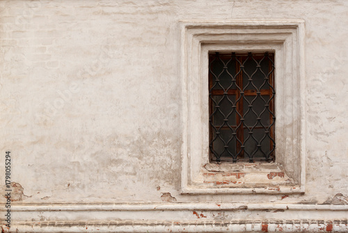 Fototapeta solid brick plastered wall with a barred window