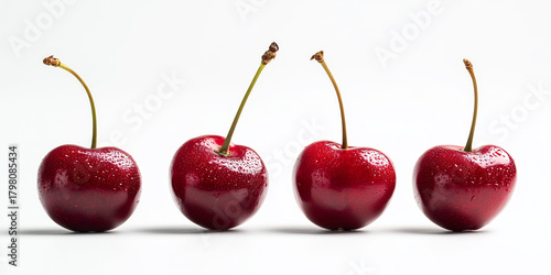 Fresh red cherries lined up on a white background showcasing their glossy texture and vibrant color