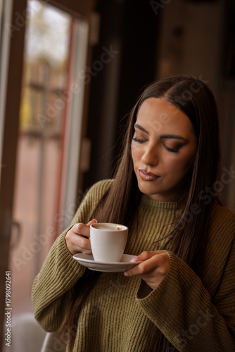 Young woman enjoys a cappuccino alone in a café