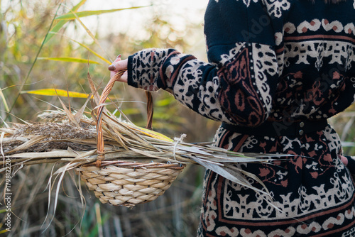 una donna tiene in mano un cestino con canne