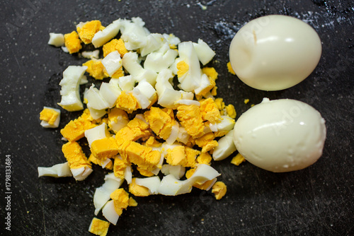 Fényképezés Close-up of diced hard-boiled eggs with bright yellow yolks and white on a dark