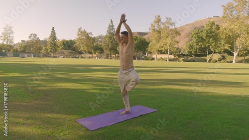 Young Fit Man Doing Outdoor Yoga and Core Workout on a Mat in the Park
