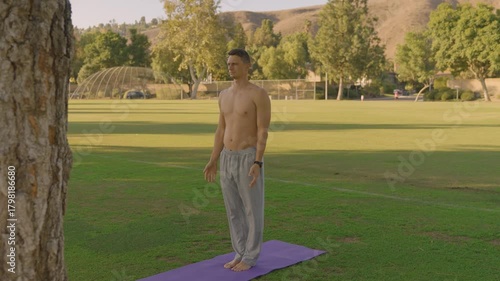 Young Fit Man Doing Outdoor Yoga and Core Workout on a Mat in the Park