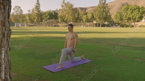 Young Fit Man Doing Outdoor Yoga and Core Workout on a Mat in the Park