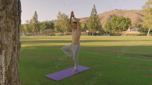 Young Fit Man Doing Outdoor Yoga and Core Workout on a Mat in the Park