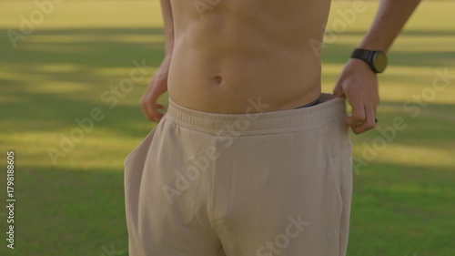 Young Fit Man Doing Outdoor Yoga and Core Workout on a Mat in the Park