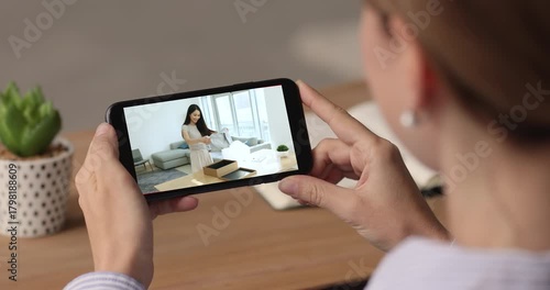 Woman watching unpacking videovlog on smartphone, close up