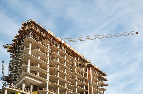 Crane and building construction site against blue sky