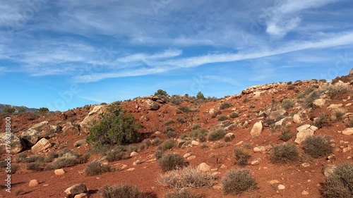 Wide desert vista with red rock mesas and sparse vegetation