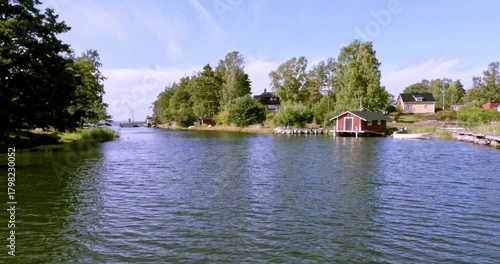 Landscape view of Nokasundet strait from moving passenger ferry in summer weather with clouds in the sky, Pirttisaari, Porvoo, Finland. 