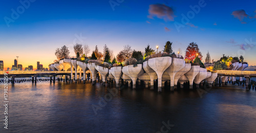 Little Island at Pier 55 silhouetted against a sunset cityscape in New York, USA