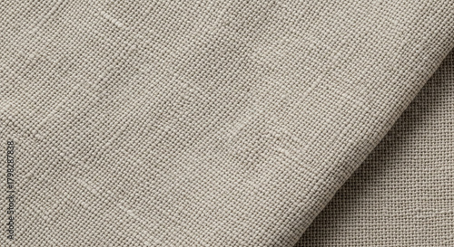 Natural, textured linen-like fabric background.
A close-up shot of a beige or natural-colored woven textile, possibly linen or a linen blend, featuring a visibly textured