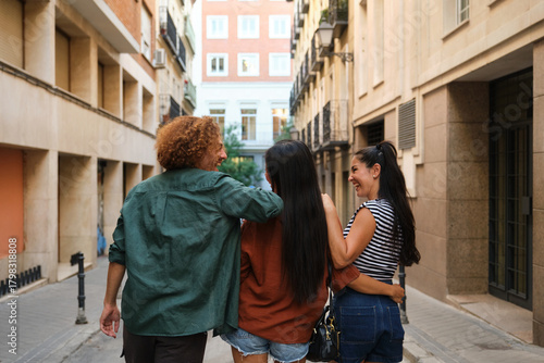 Group of friends walking down a narrow street in Madrid, Spain, enjoying their vacation