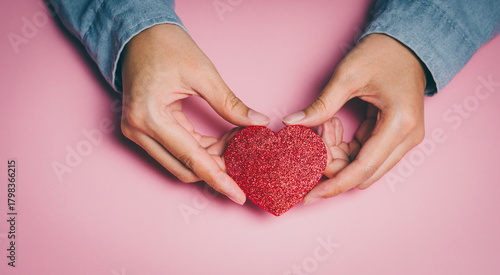 Hands framing glitter red heart, emotional wellbeing awareness, kindness expression, compassion support insight, mental care reflection, love appreciation and positive connection concept