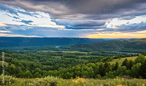 Majestic valley bathed in sun rays with a winding river and dramatic clouds