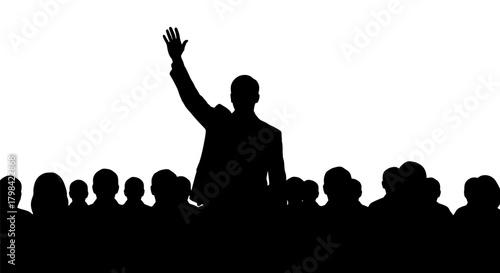 A silhouetted speaker with a raised hand addresses a crowd