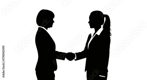 Two women in suits shake hands, silhouetted against white