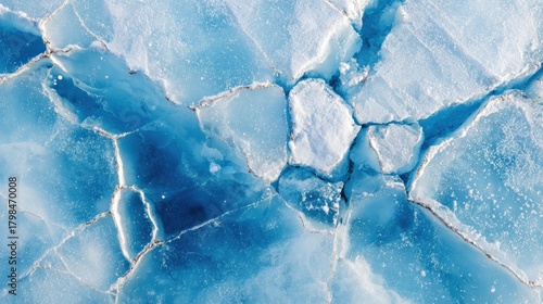 Aerial view of cracked ice formations.  Fractured blue & white surface, intricate patterns