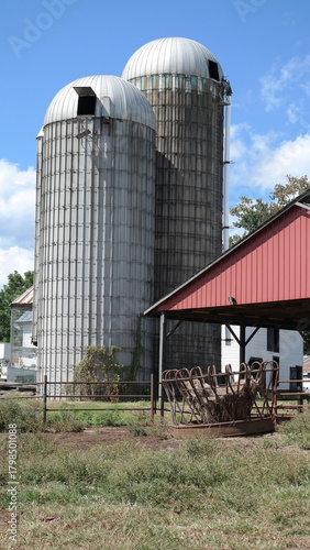 Duo Farm Silos beside red shed and hay feeder