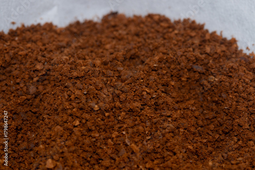 Super macro close-up of medium roast coffee powder prepared for drip brewing.