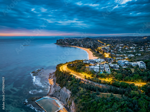 Seaside Sunrise with rain clouds, sea pool, headlands and houses