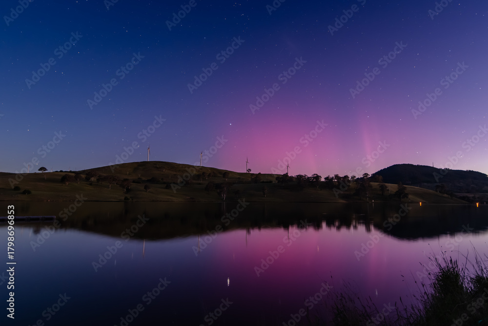 Obraz premium Aurora Australis display lights up the sky in pinks over the dam