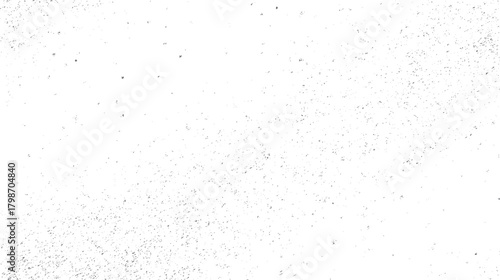 White background with scattered dark grey speckles and small irregular shapes creating a textured pattern