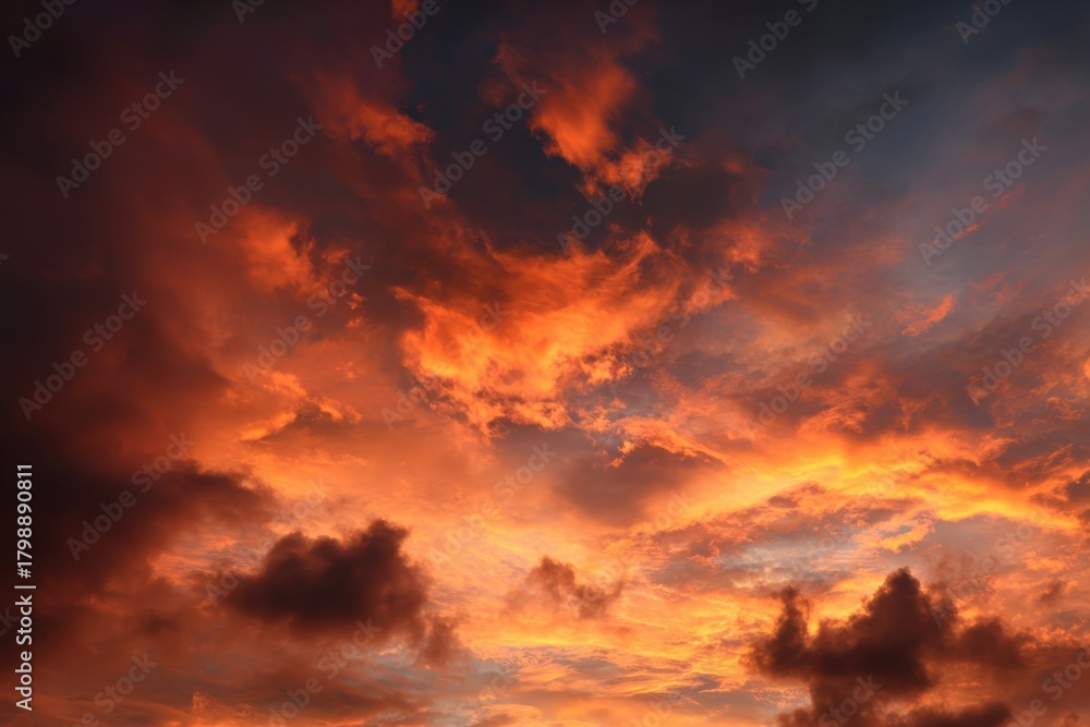 Fototapeta premium Vibrant sunset sky filled with fiery orange and red hues over a peaceful landscape reflecting the beauty of twilight in nature