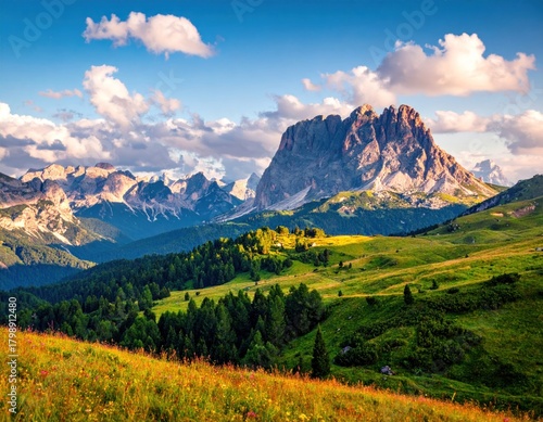 Fototapeta Naklejka Na Ścianę i Meble -  Sunny mountain vista with lush green valley and dramatic peaks