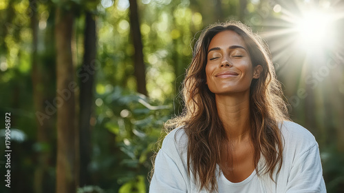 Fototapeta Naklejka Na Ścianę i Meble -  Serene woman breathing forest air, eyes closed, sunlight streaming, relaxed expression